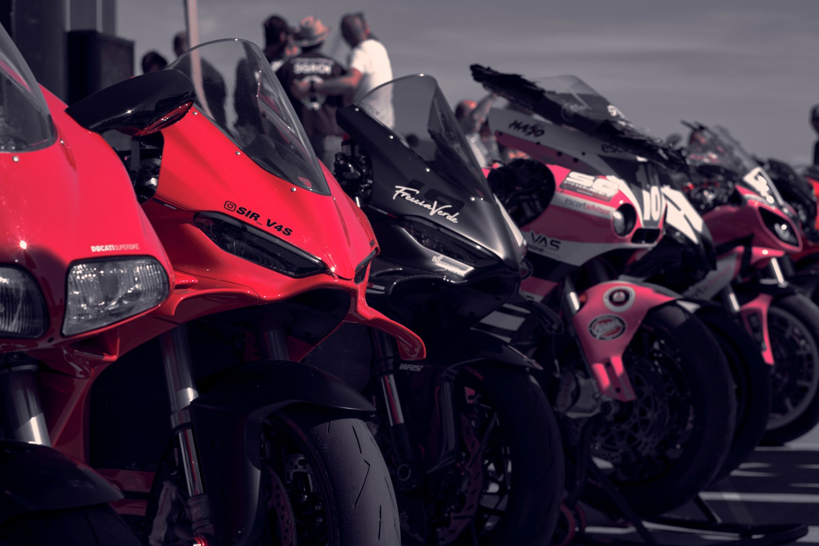 Row of colorful sport motorcycles parked outdoors.